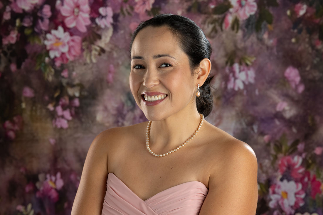 woman in pink dress with floral backdrop portrait