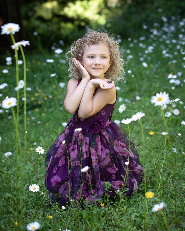 cute girl posing by grass and daisies