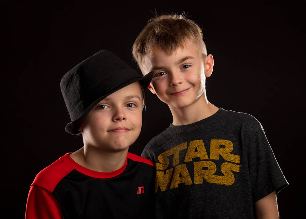 indoor portrait two boys brothers on black
