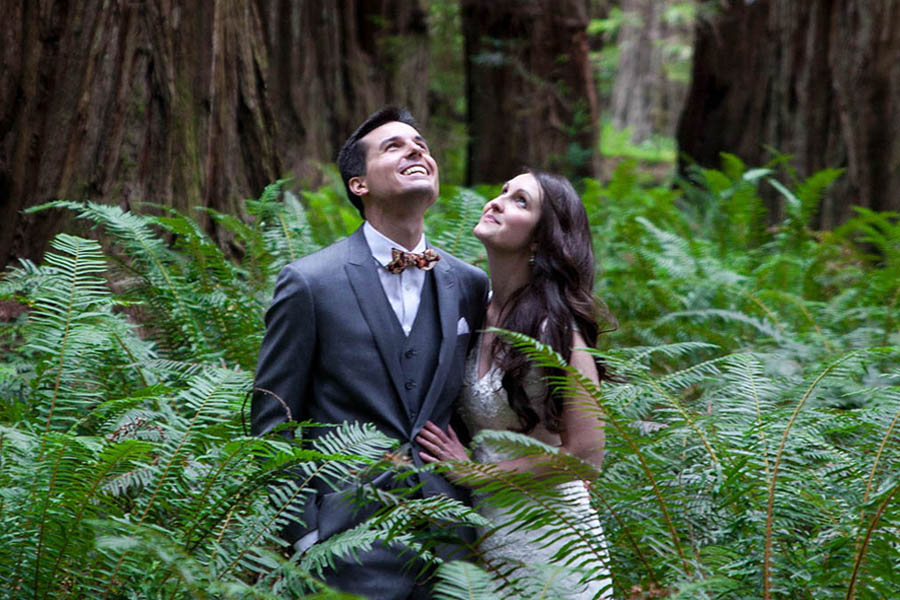 wedding couple standing among ferns