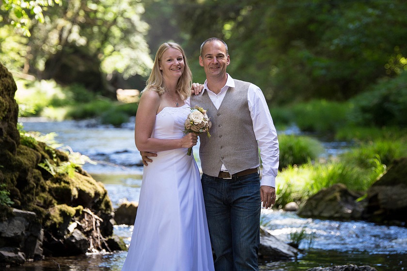 wedding couple standing by a river