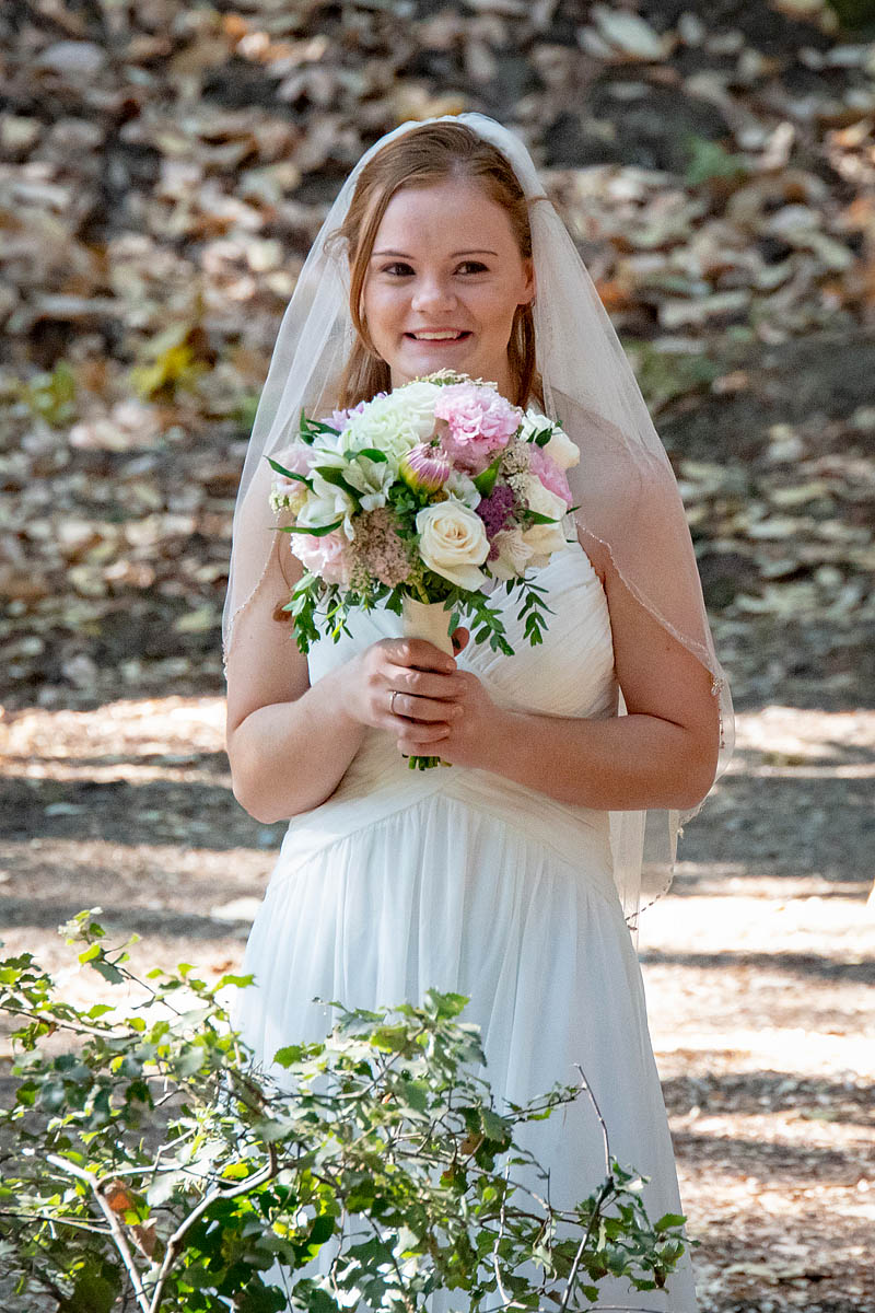 bride holding wedding bouquet in forest